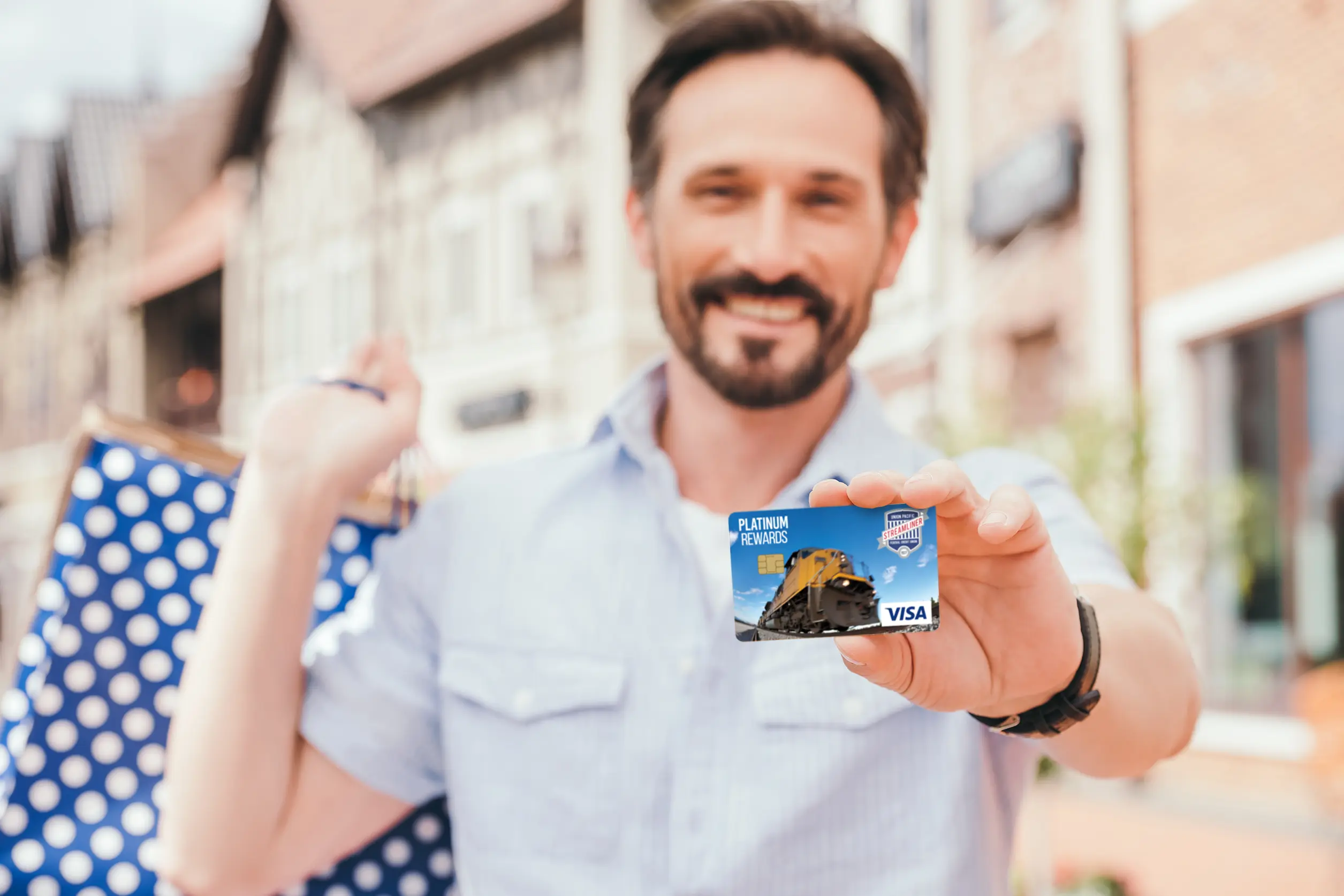 happy shopper showing the camera his Union Pacific Streamliner Federal CU credit card