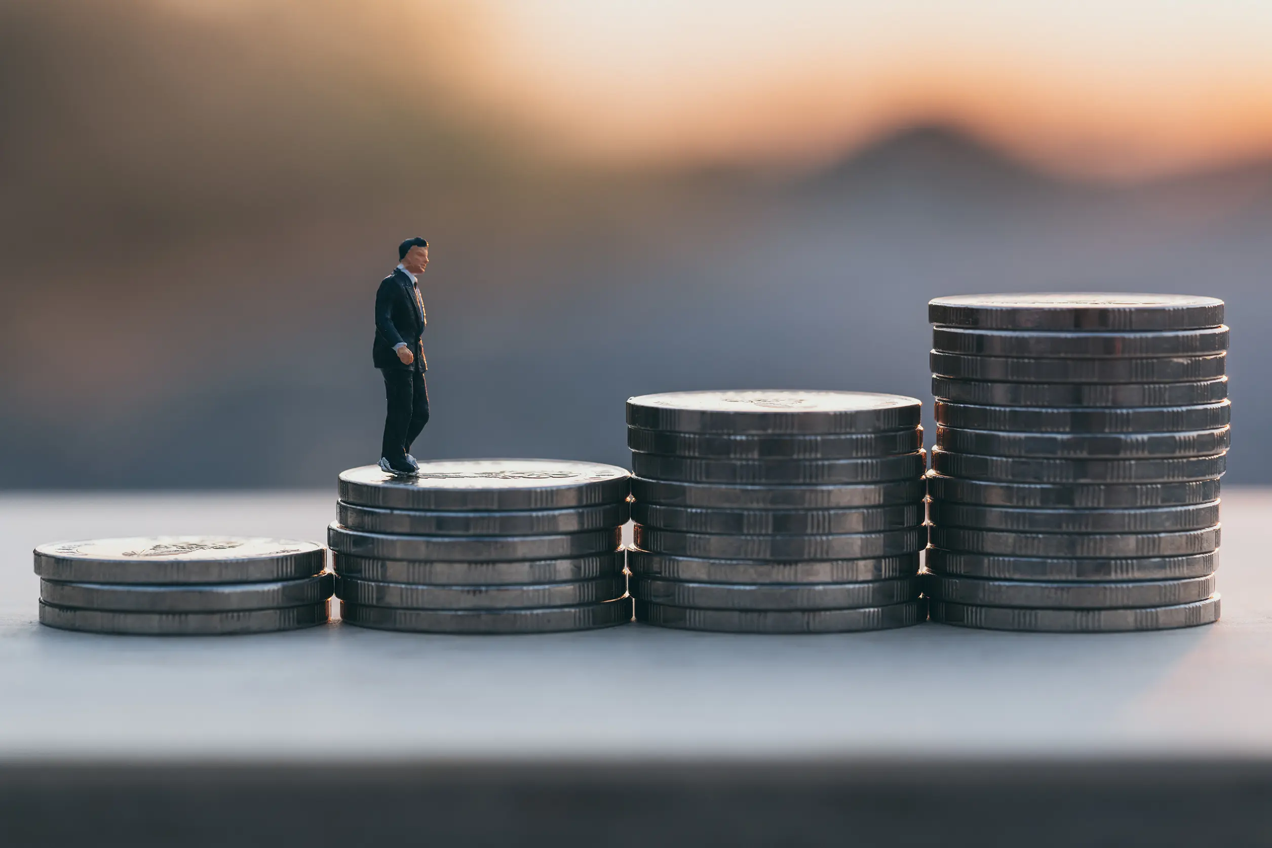 stacks of coins with a small action figure walking up