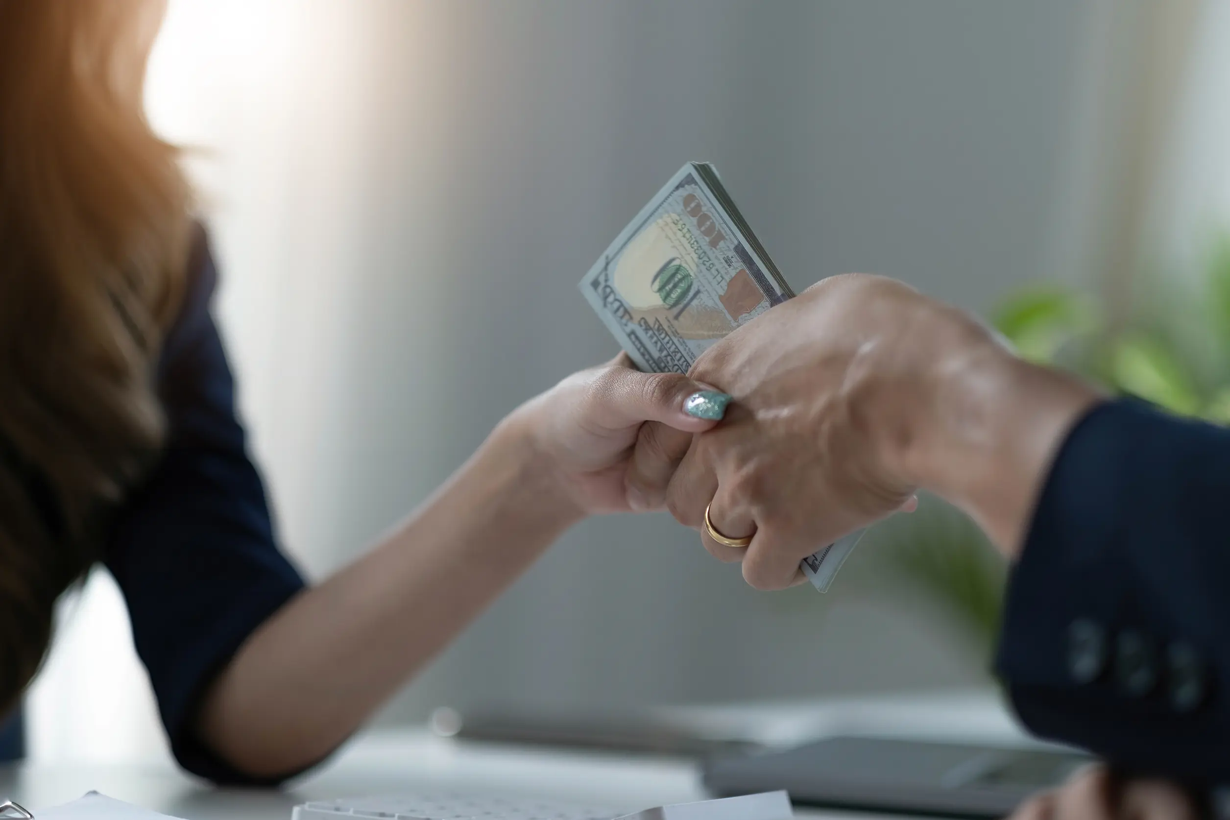 two people extending hands and passing money