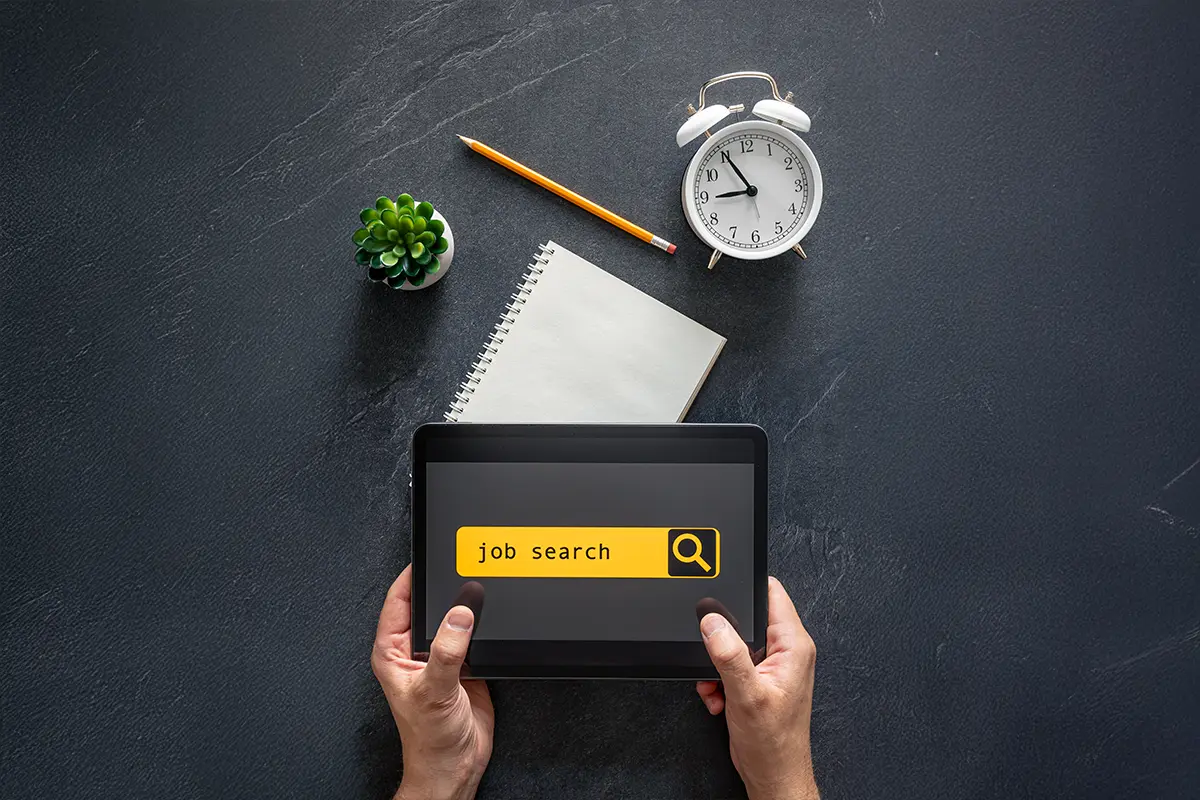 aerial view of a desk with someone job searching on a tablet
